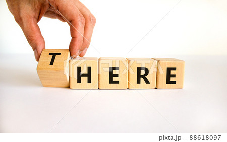 There or here symbol. Businessman turns a wooden cube, changes the word 'there' to 'here'. Beautiful white table, white background, copy space. Business, there or here concept. There or here symbol. Businessman turns a wooden cube, changes the word 'there' to 'here'. Beautiful white table, white background, copy space. Business, there or here concept. 88618097