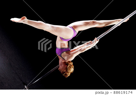 The strong and graceful young girl performing acrobatic exercises on pylon 88619174