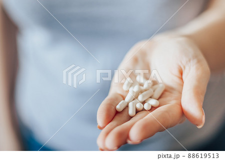 Womans hand is holding pills. Overdose of medicinal capsules in palms close-up. World Health Day. 88619513