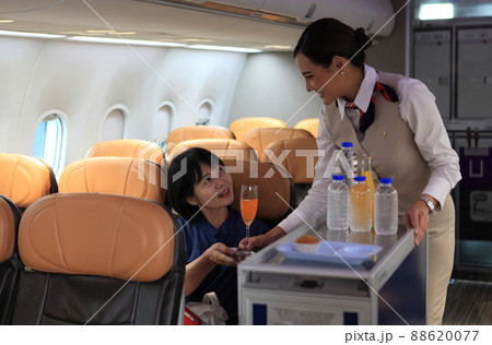 Cabin crew pushing service cart and serve to customer on the airplane during flight. hostess service on plane Cabin crew pushing service cart and serve to customer on the airplane during flight. hostess service on plane 88620077