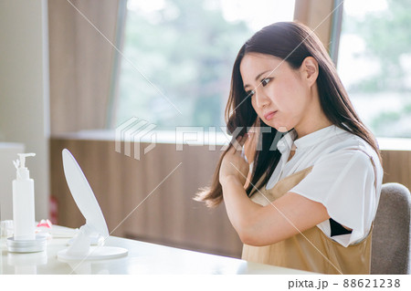 ヘアブラシで髪をとかす女性(困る) ヘアブラシで髪をとかす女性(困る) 88621238