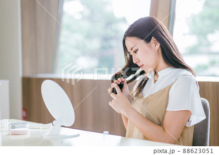 整髪料をつける女性(悩む) 整髪料をつける女性(悩む) 88623051