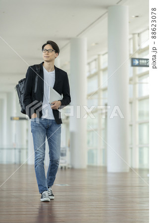 ノートパソコンとバックパックを持って歩く30代の男性 ノートパソコンとバックパックを持って歩く30代の男性 88623078