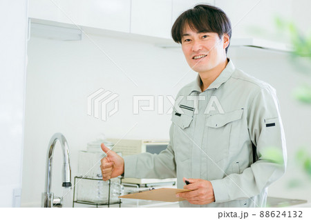 キッチンと作業着姿の男性（水道・カメラ目線） 88624132