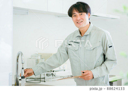 キッチンと作業着姿の男性（水道・カメラ目線） 88624133