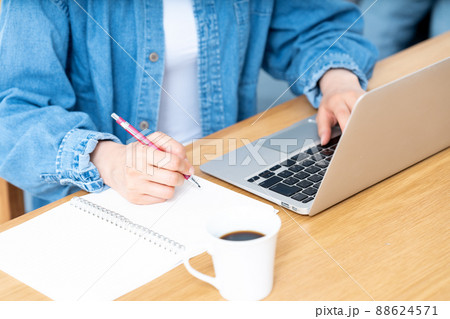 メモをとりながらノートパソコンを使う女性の手元【パーツカット】 メモをとりながらノートパソコンを使う女性の手元【パーツカット】 88624571