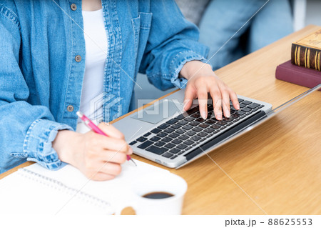 メモをとりながらノートパソコンを使う女性の手元【パーツカット】 88625553