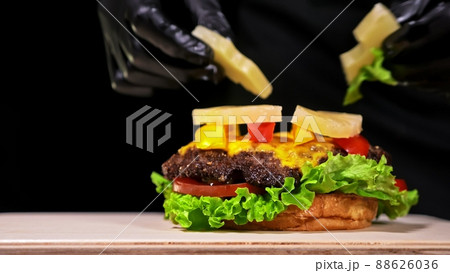 Craft burger is cooking. Consist: red sauce salsa, lettuce, red onion, pickle, cheese, chilli green pepper, air bun and marbled meat beef. Craft burger is cooking. Consist: red sauce salsa, lettuce, red onion, pickle, cheese, chilli green pepper, air bun and marbled meat beef. 88626036