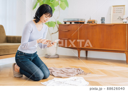 フリマサイトに出品する洋服を撮影する女性 フリマサイトに出品する洋服を撮影する女性 88626040