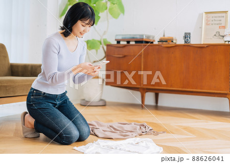 フリマサイトに出品する洋服を撮影する女性 フリマサイトに出品する洋服を撮影する女性 88626041