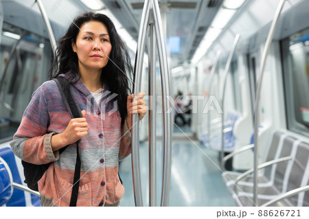 Portrait of woman with backpack standing in subway train Portrait of woman with backpack standing in subway train 88626721