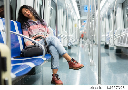 Young woman passenger sleeping in subway car 88627303