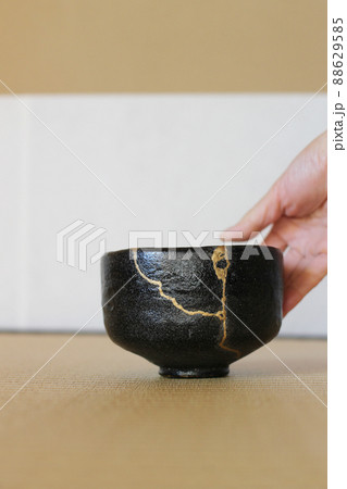 金継ぎされた黒い抹茶茶碗を右手でおもてなし　茶道と日本の伝統工芸 88629585
