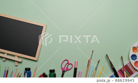Top view empty chalkboard and school stationery on green background. Back to school concept. Top view empty chalkboard and school stationery on green background. Back to school concept. 88629945
