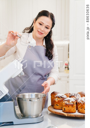 a woman cook prepares icing, fondant or marshmallow to decorate easter cakes. a woman cook prepares icing, fondant or marshmallow to decorate easter cakes. 88630636