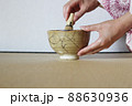 金継された抹茶茶碗で着物の女性がお茶を点てる 88630936