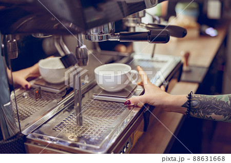Female barista using professional coffee machine in coffeehouse 88631668