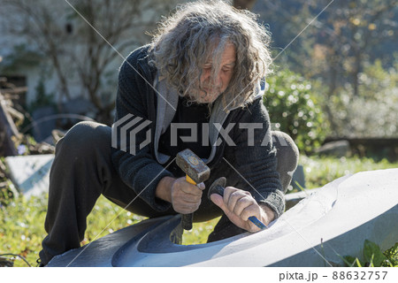 Tired senior artist carving in stone 88632757