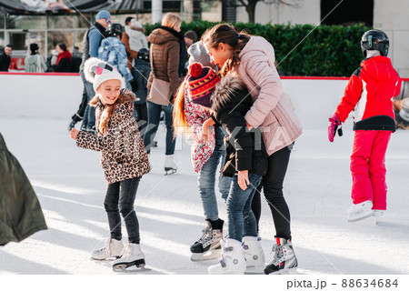 Soft,Selective focus.People, friendship, sport and leisure concept - happy friends on skating rink.Group of teenage friends ice skating on an ice rink.Outdoor.Winter sport. 88634684