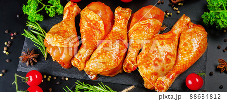 Convenience food, precooked.Raw Marinated chicken meat legs with spices for cooking for BBQ dark background. Top view. Convenience food, precooked.Raw Marinated chicken meat legs with spices for cooking for BBQ dark background. Top view. 88634812