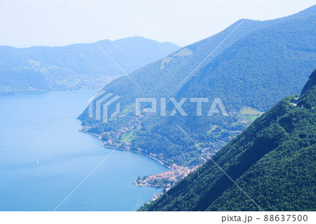 Picturesque summer landscape. Aerial view of lake Iseo, forested mountains, various villages scattered along the mountain slopes and along the coast. Picturesque summer landscape. Aerial view of lake Iseo, forested mountains, various villages scattered along the mountain slopes and along the coast. 88637500