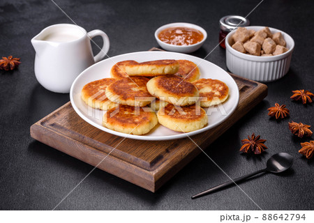 Cottage cheese pancakes with oats, syrniki on a black rustic background 88642794