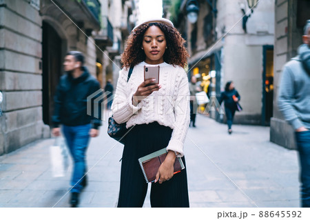 Beautiful 20s african american female checking notification on mobile phone of banking app 88645592