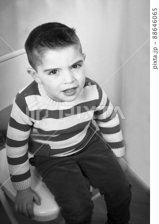 Three year old boy sitting in a chair 88646065