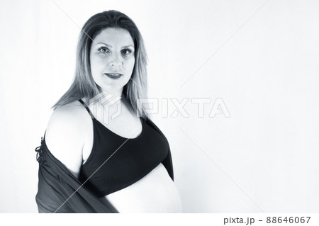 Eight month pregnant woman with bare belly 88646067