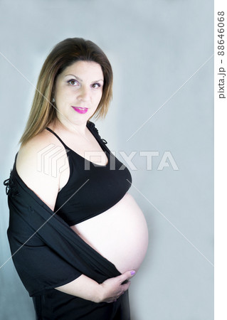Eight month pregnant woman with bare belly 88646068