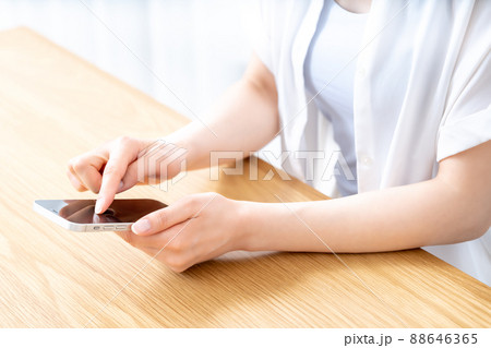 テーブルでスマホを使う女性の手元【パーツカット】 テーブルでスマホを使う女性の手元【パーツカット】 88646365