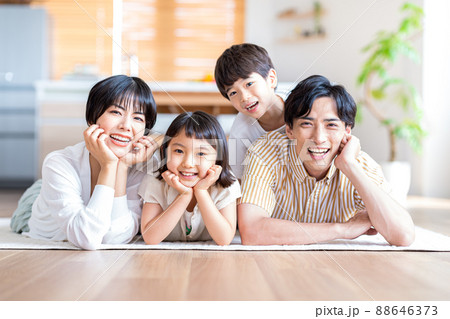 リビングルームで寝そべる4人家族 88646373