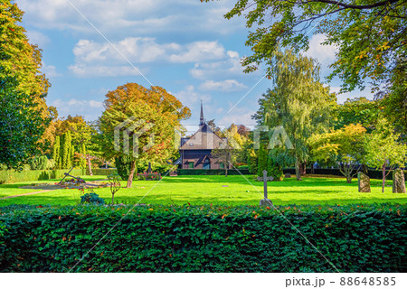 Lots of green trees, bushes, flowers and old chapel at Holmen Cemetery. Copenhagen, Denmark 88648585