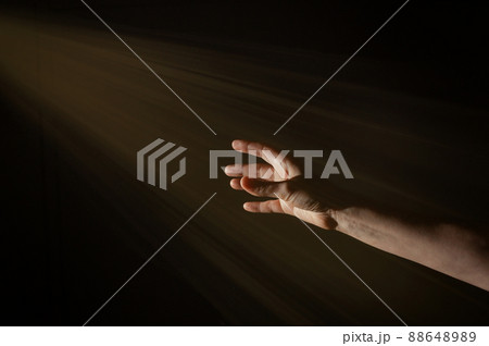 Light Rays Shihing On Man's Hand In Darkness 88648989