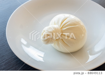 Buratta cheese on a white plate. Side view from above 88649113