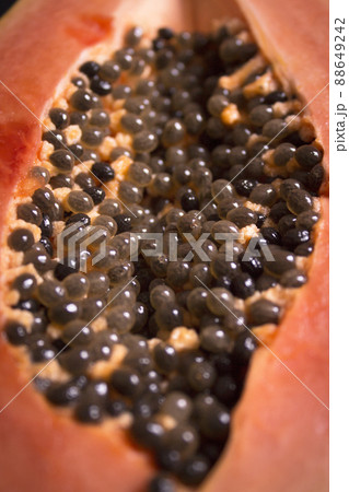Half of an open papaya with the seeds 88649242
