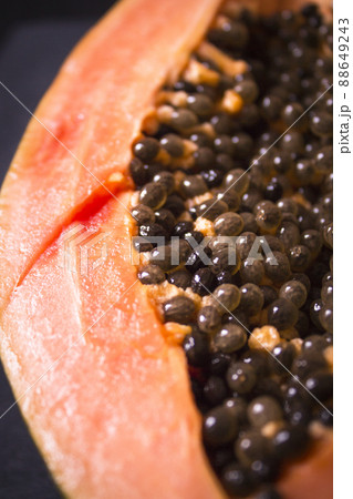 Half of an open papaya with the seeds 88649243