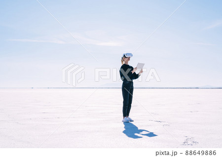 Young woman with VR glasses and tablet at Salt Flats Young woman with VR glasses and tablet at Salt Flats 88649886