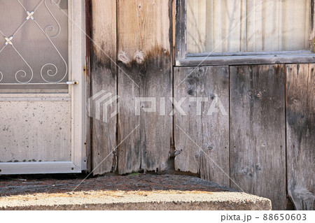 Close up of Weathered Wood Siding Beginning to Rot Around Front Step of Cottage or House Close up of Weathered Wood Siding Beginning to Rot Around Front Step of Cottage or House 88650603
