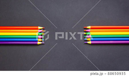 Pencils lie on top Bright social colors lgbt. LGBT colors corrugated cardboard flag. Copy space. Blank for advertising hobby drawing. Beautiful black background. Pencils lie on top Bright social colors lgbt. LGBT colors corrugated cardboard flag. Copy space. Blank for advertising hobby drawing. Beautiful black background. 88650935