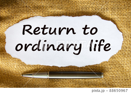 The text 'return to odinary life' on white paper. Metalic pen. Beautiful canvas background. Business concept. 88650967
