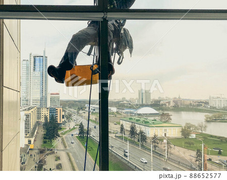 A window washing the windows of an office building. 88652577