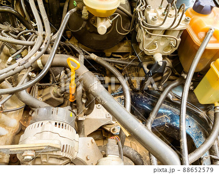 Close up of a car with open hood under under maintenance in auto repair shop. Car service, repair, maintenance concept. Selective focus. Horizontal shot. 88652579