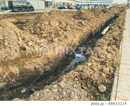 sandy ditch with communications. pipes are being laid in a new microdistrict of the city to bring communications to residential buildings sandy ditch with communications. pipes are being laid in a new microdistrict of the city to bring communications to residential buildings 88653124