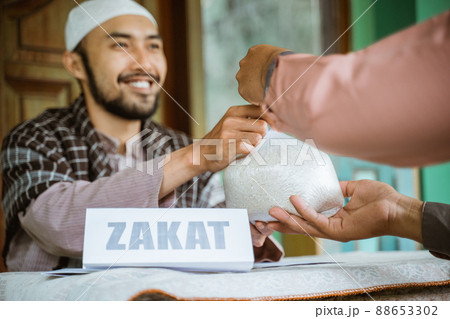 man giving a rice as a food donation for zakat during eid mubarak man giving a rice as a food donation for zakat during eid mubarak 88653302