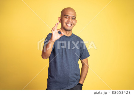 asian bald man showing okay hand gesture with smiling asian bald man showing okay hand gesture with smiling 88653423