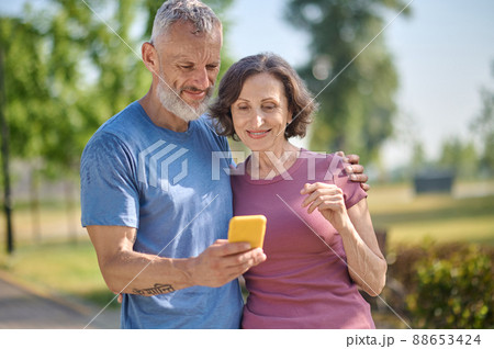 A happy couple in the park feeling good and making selfie A happy couple in the park feeling good and making selfie 88653424