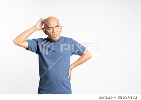 confused bald man holding his bald head 88654172
