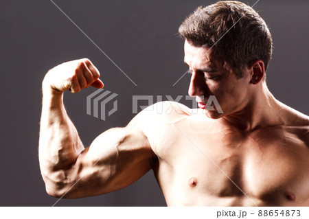 pain relief, sport, bodybuilding, strength and people concept - young man standing over black background 88654873