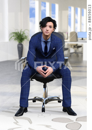 オフィスで椅子に座り、こちらを見ている紺色のスーツを着た若いビジネスマン 88656013